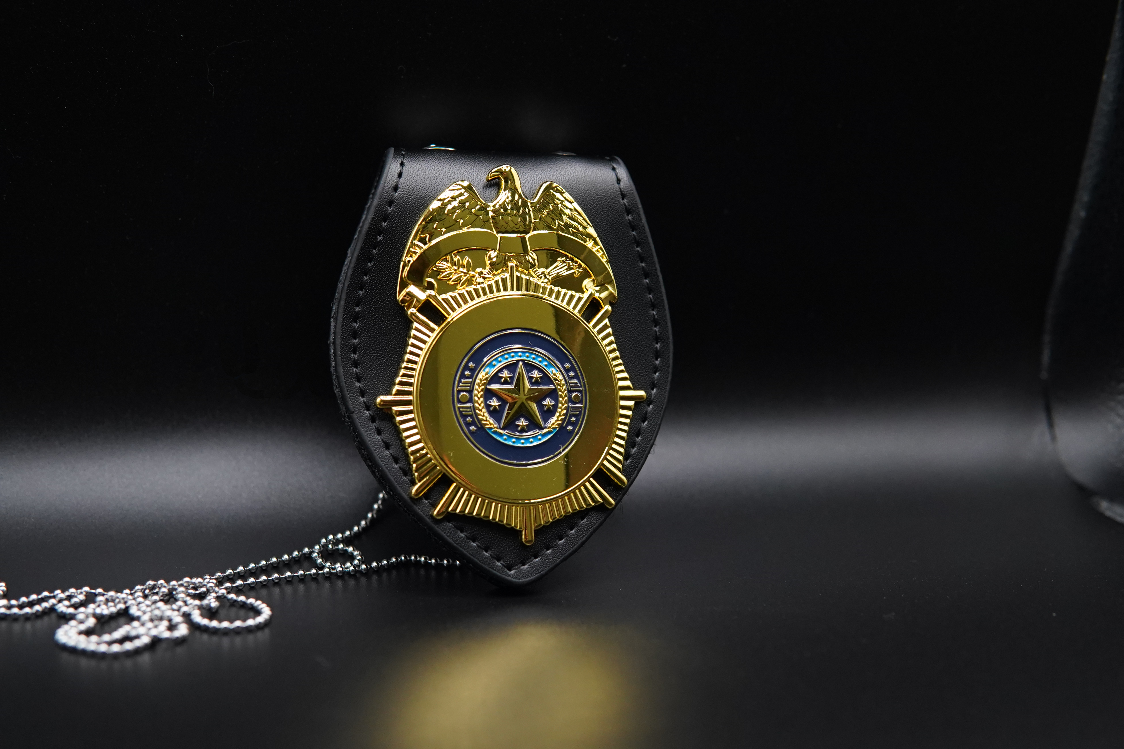 Gold custom police badge with eagle crest on a leather holder